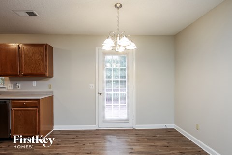 A kitchen with wooden cabinets and a chandelier hanging from the ceiling.