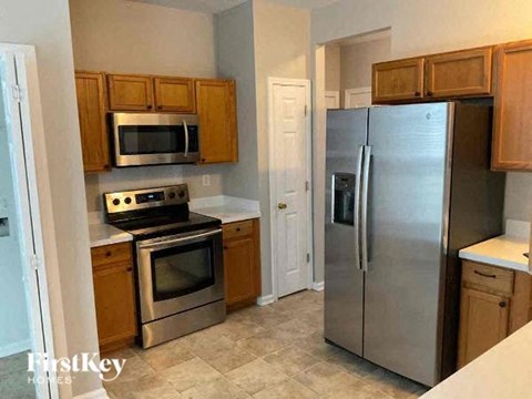 A kitchen with a stove top oven and a refrigerator.