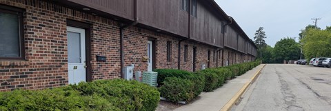 A long building with a white door and windows.