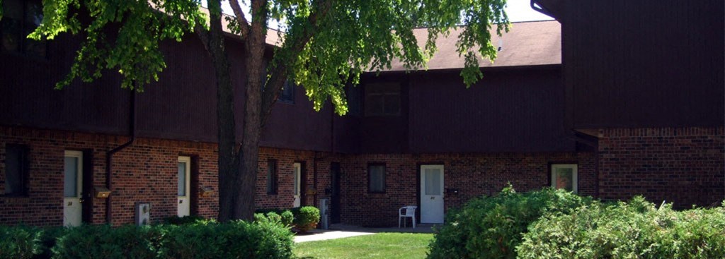 a red brick building with a tree in front of it