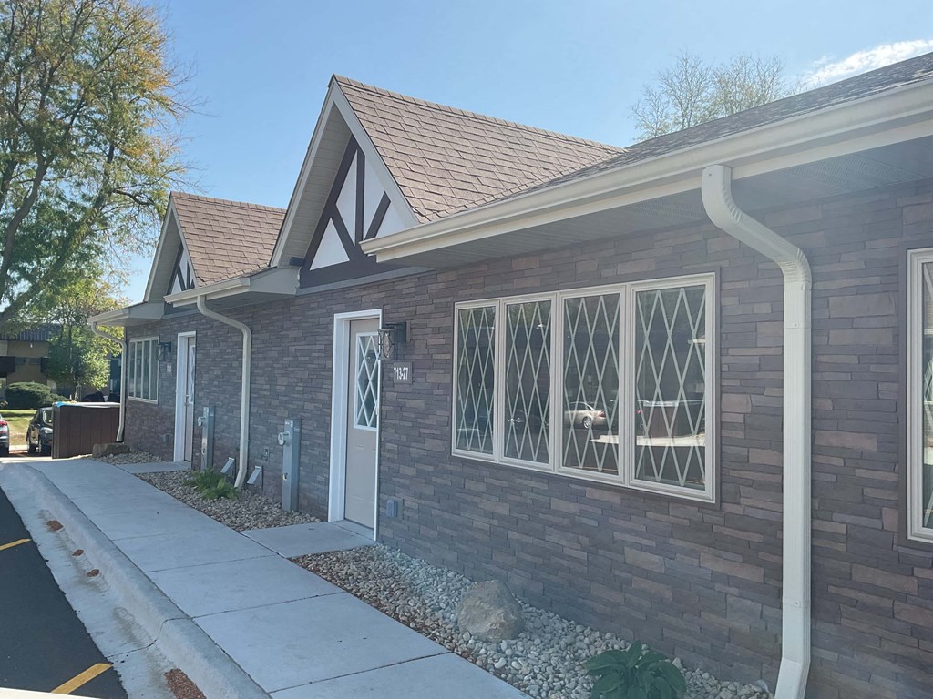 a brick house with a sidewalk in front of it