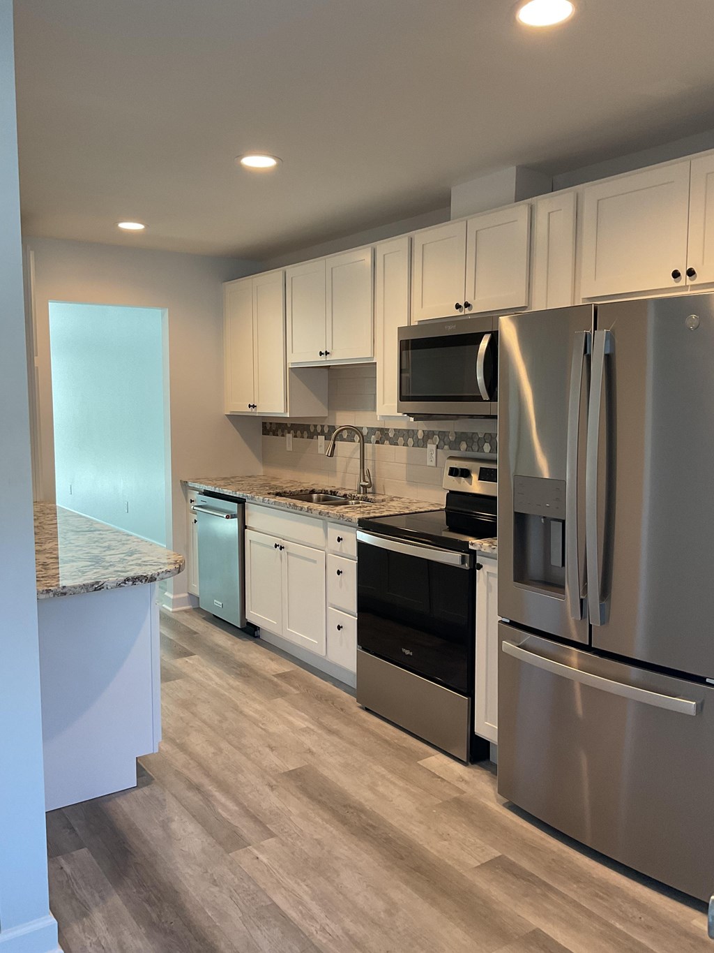 A modern kitchen with stainless steel appliances and white cabinets.