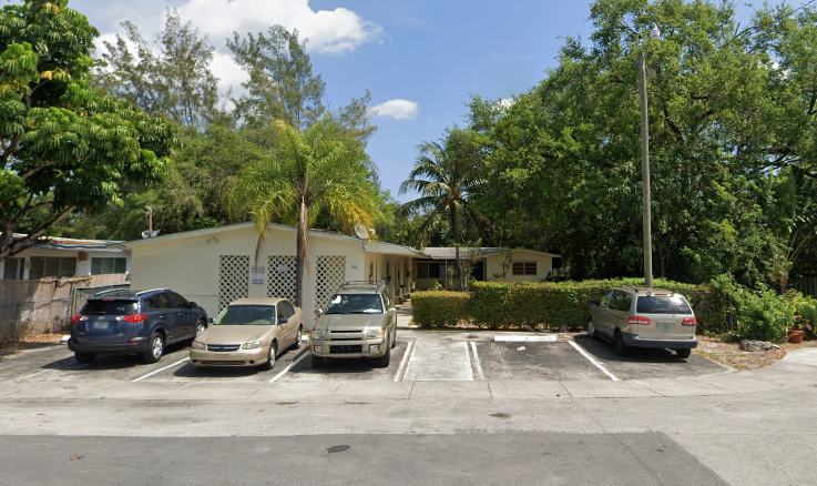 a parking lot with cars in front of a house