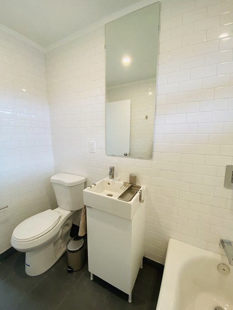 a bathroom with a toilet and a sink and a mirror