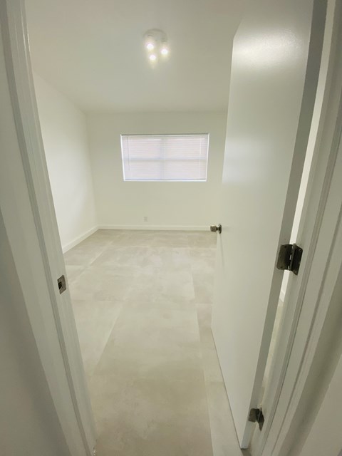 a white room with a window and a white door