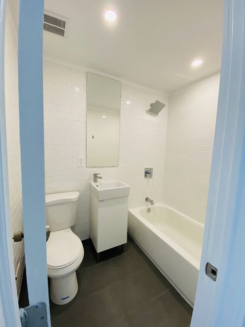 a bathroom with a toilet and a tub and a sink