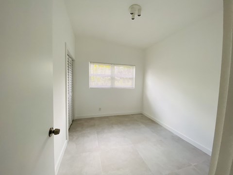 an empty room with white walls and a window