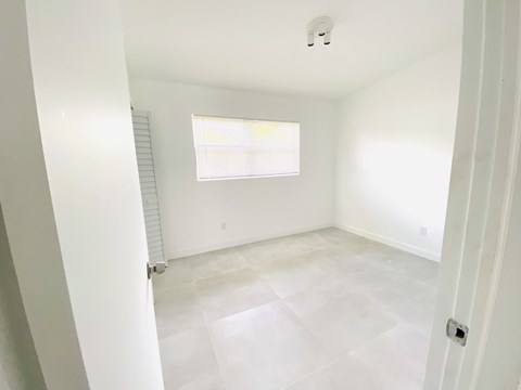 an empty room with white walls and a window