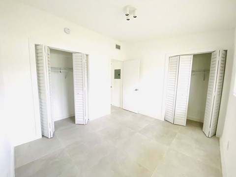 an empty room with three closets and a tiled floor