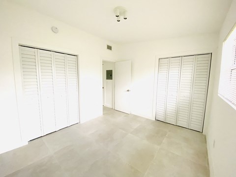 an empty living room with white walls and two doors