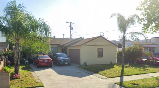 A house with a red car parked in front.