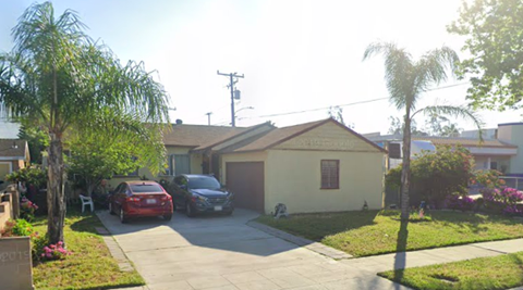 A house with a red car parked in front.