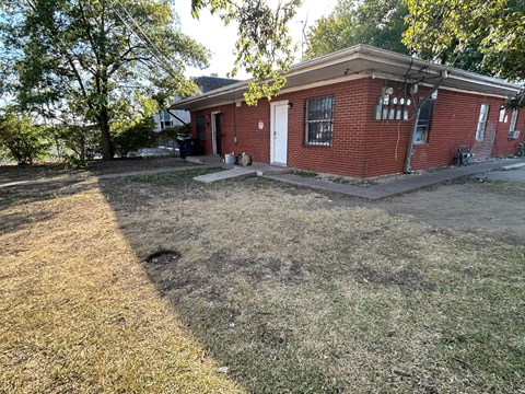 A red brick house with a white door and windows.