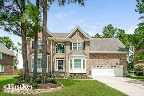a large brick house with a garage and trees