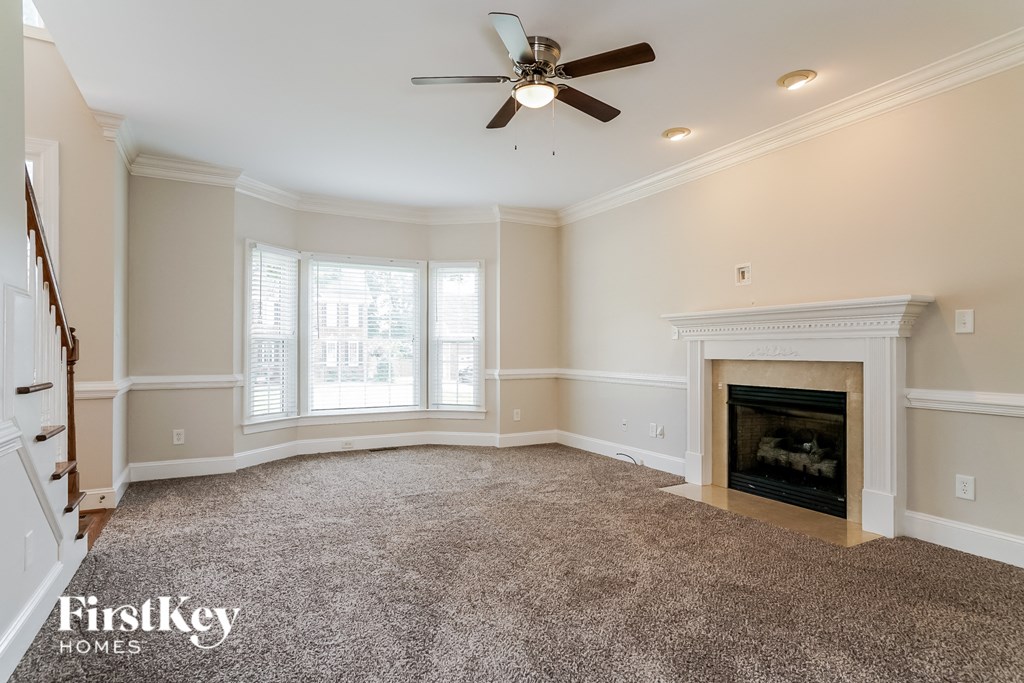 a living room with a fireplace and a ceiling fan