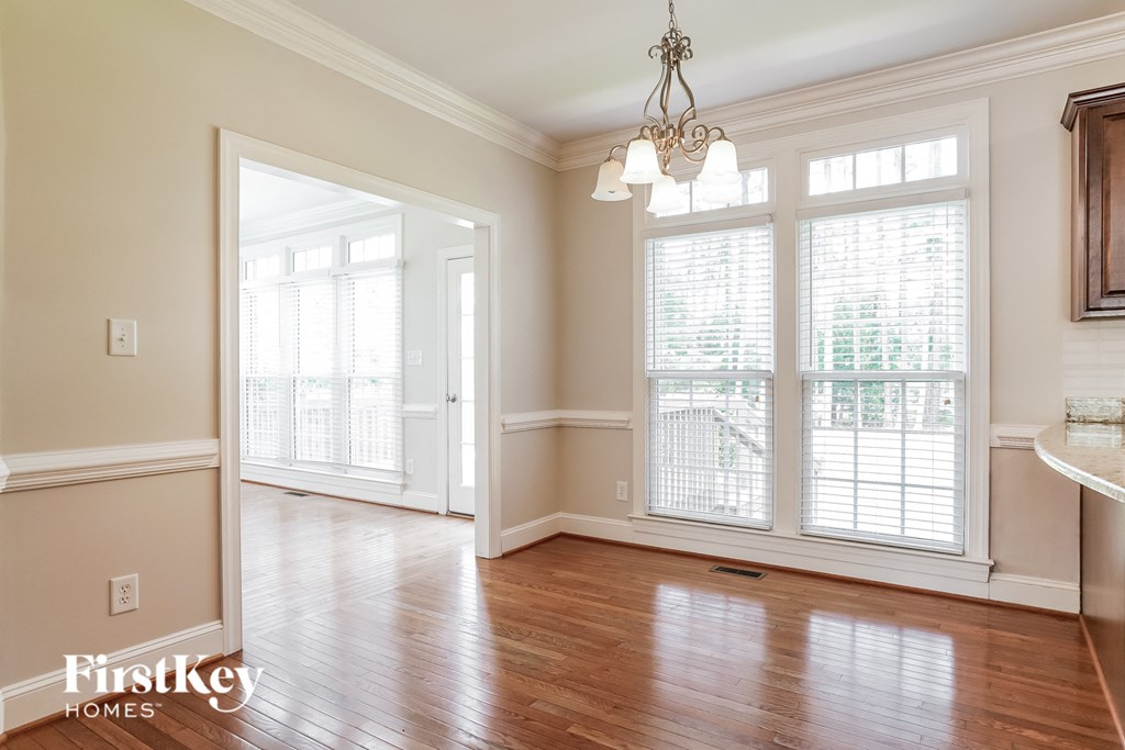 an empty living room with large windows and wood floors