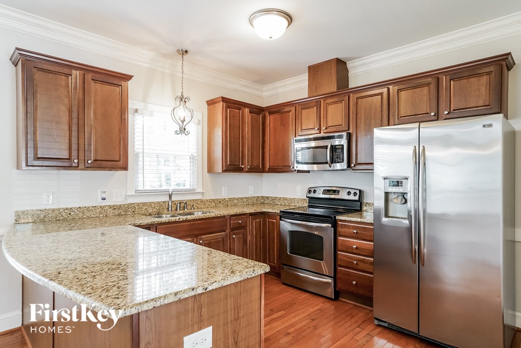 a kitchen with wooden cabinets and granite counter tops and stainless steel appliances