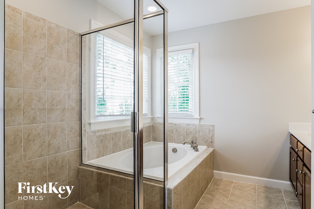 a bathroom with a tub and a shower and a window