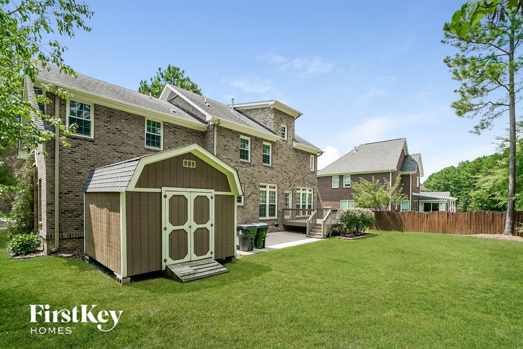 a backyard with a shed on the side of a house