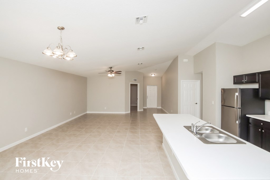 an empty kitchen and living room with a sink and refrigerator