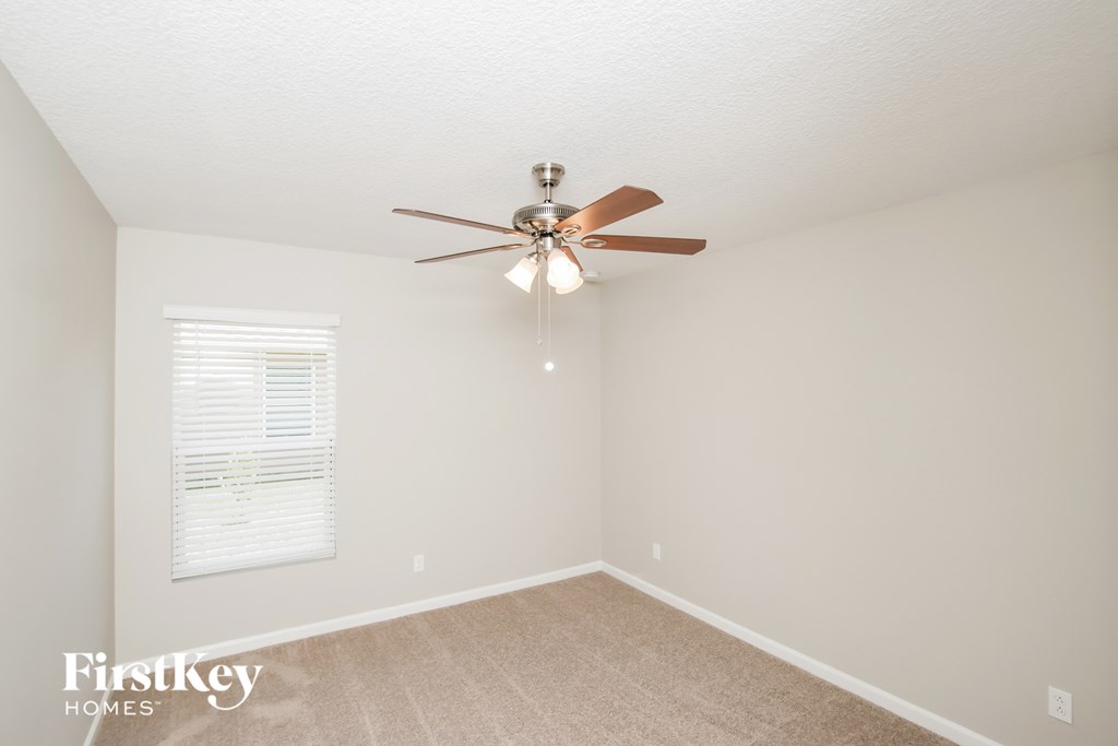 a bedroom with a ceiling fan and a window
