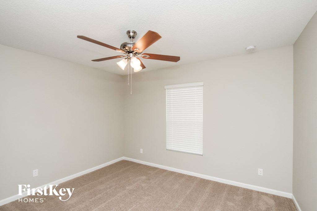 a bedroom with a ceiling fan and a window