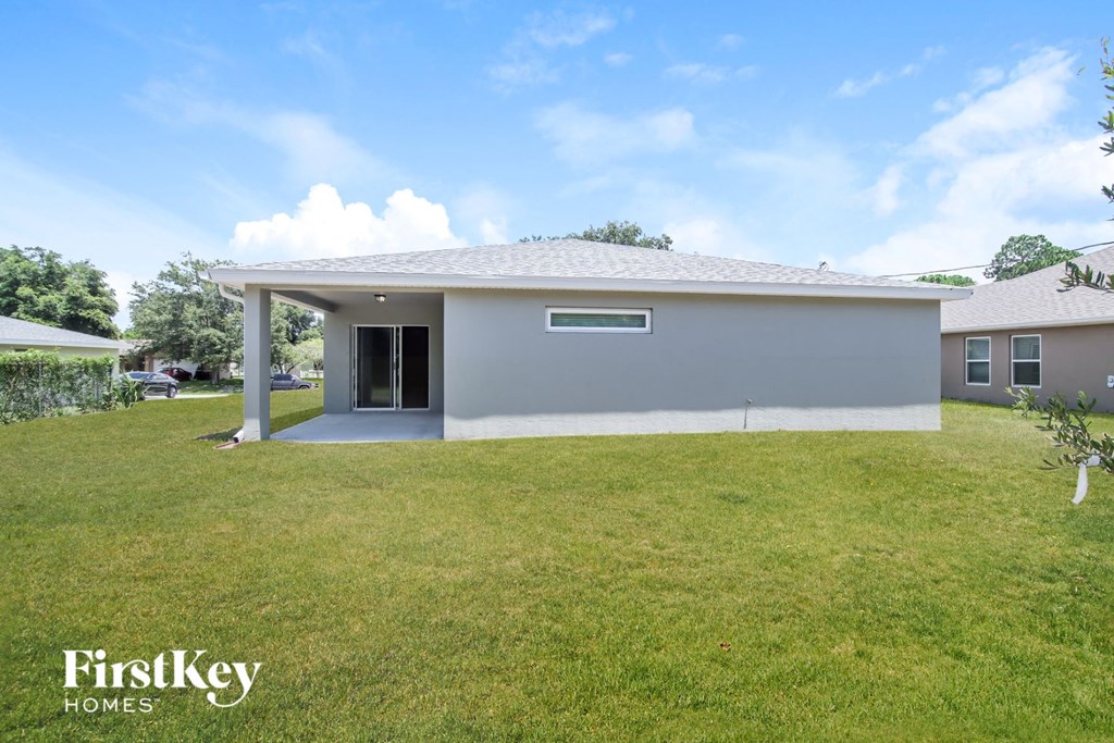a white house with a grassy yard and a garage