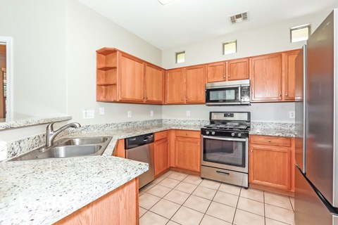 A kitchen with a stove top oven and a refrigerator.
