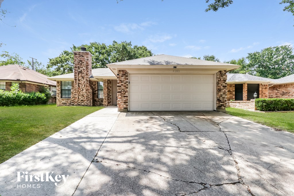 a white garage door on a brick house with a driveway
