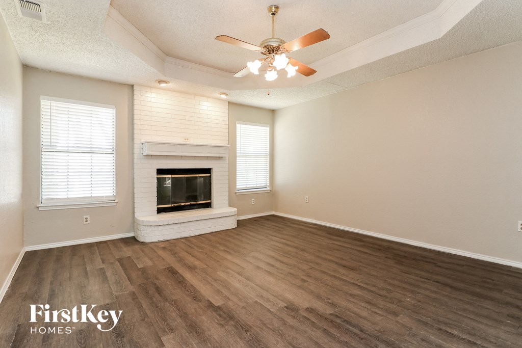a living room with a fireplace and a ceiling fan