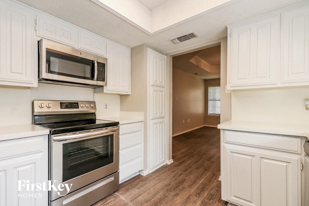 a kitchen with white cabinets and stainless steel appliances