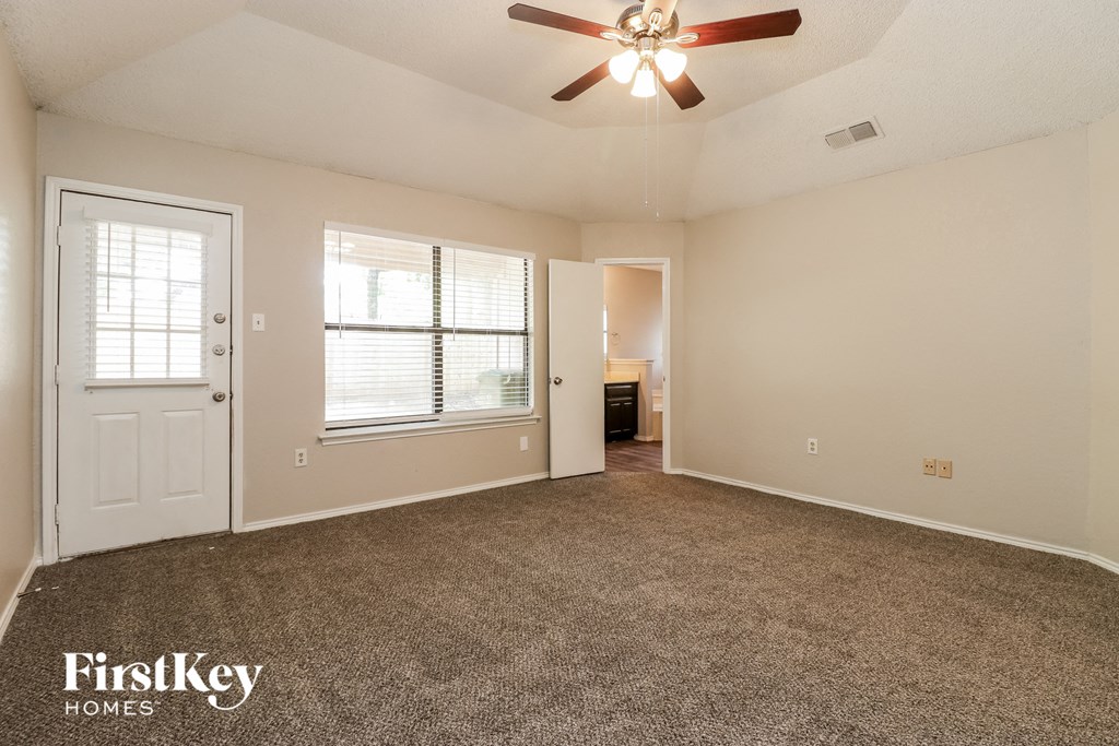 the living room of an empty house with a ceiling fan