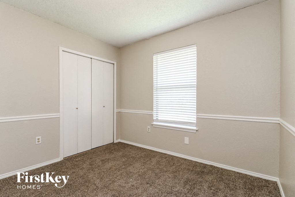 a bedroom with carpet and a door to a closet