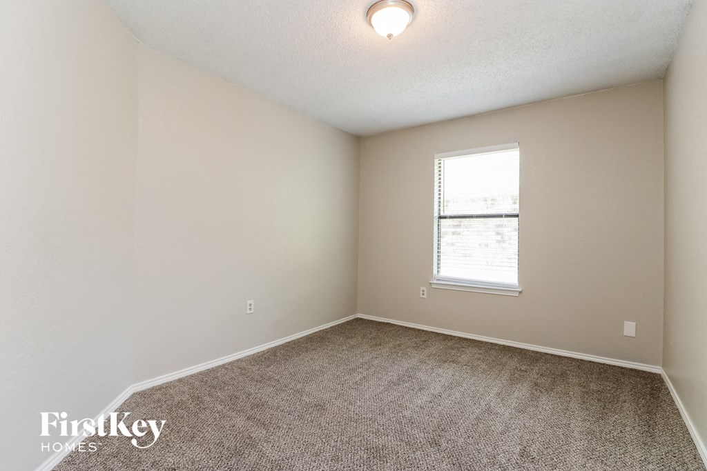 an empty room with carpet and a window