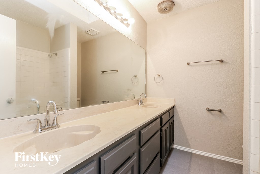 a bathroom with two sinks and a large mirror