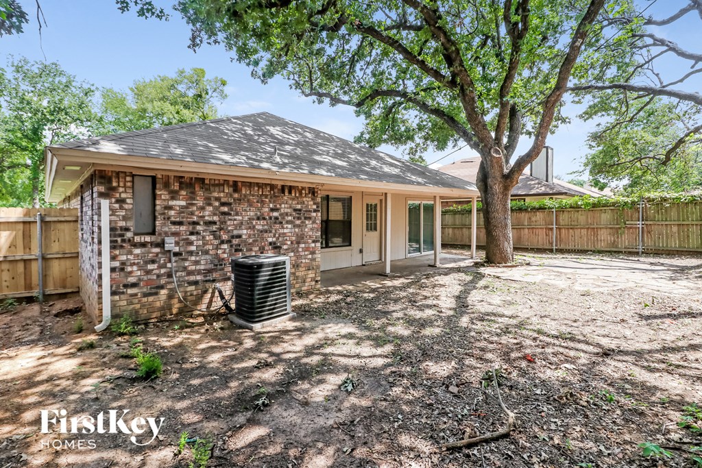 a small brick house with a yard and a tree