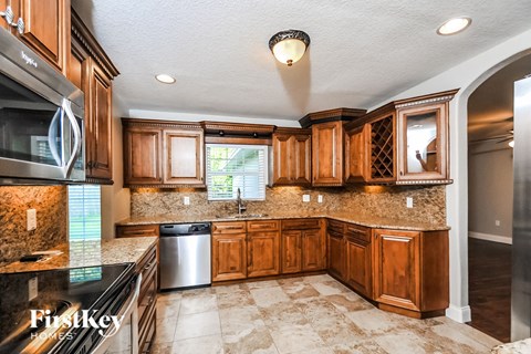 A kitchen with wooden cabinets and granite countertops.