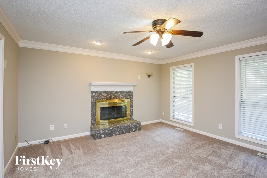 the living room has a fireplace and a ceiling fan