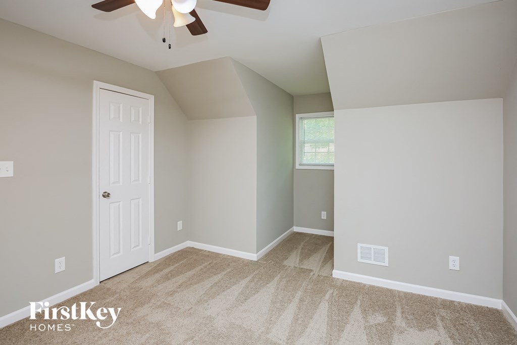 a bedroom with a ceiling fan and a white door