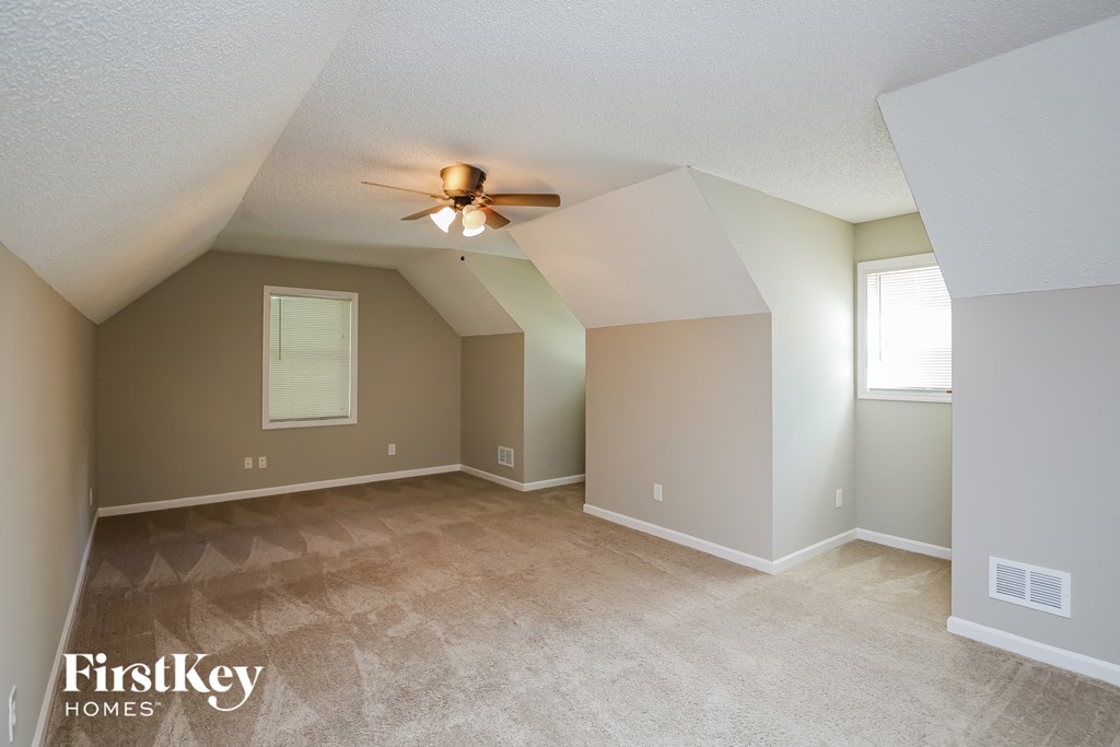 the spacious living room with vaulted ceilings and a ceiling fan
