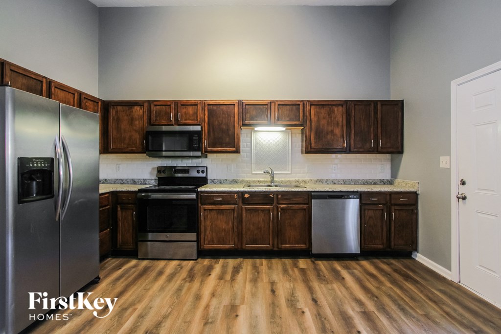 a kitchen with wooden cabinets and stainless steel appliances