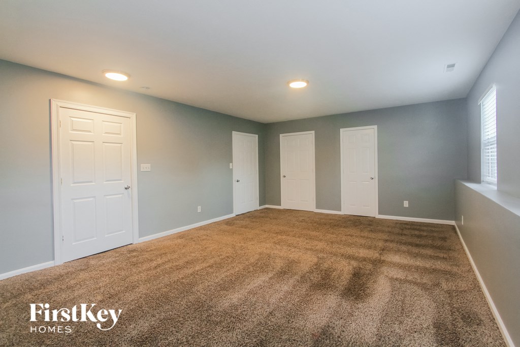 a empty room with a carpeted floor and two white doors