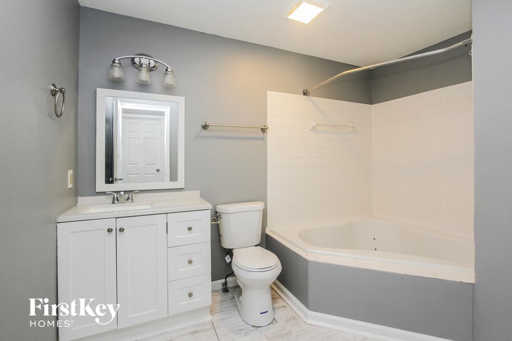 a white bathroom with a tub and a sink and a toilet
