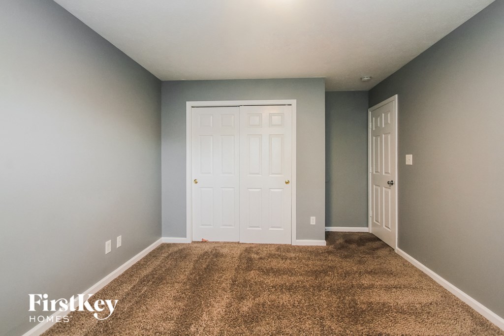 a room with a carpeted floor and a white door