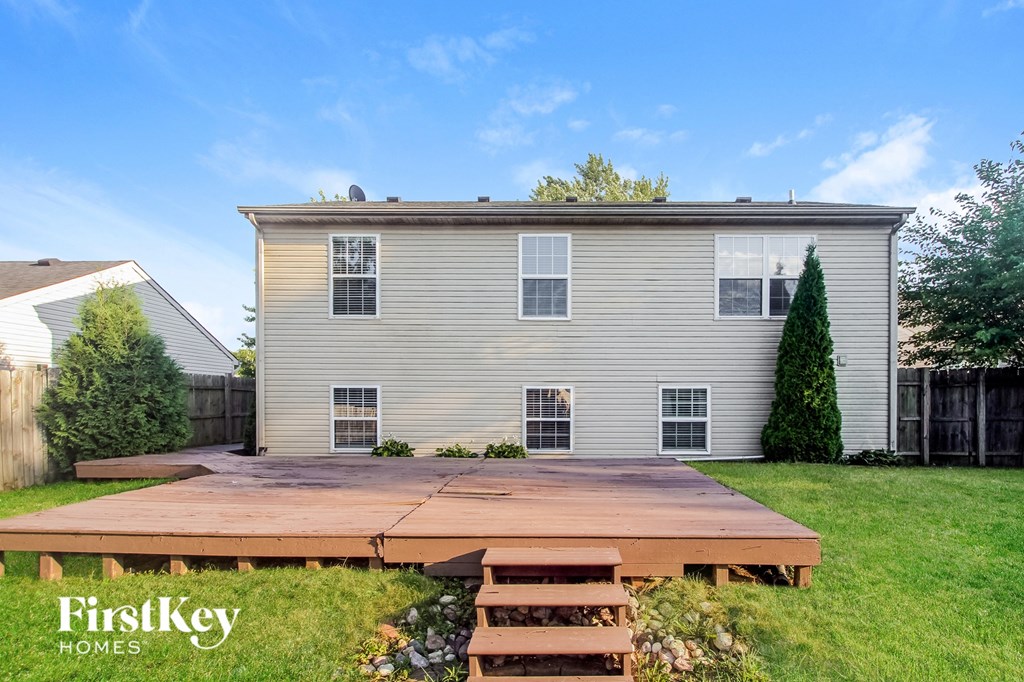 a backyard with a wooden deck and a house
