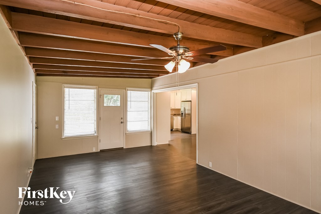a living room with wood floors and a ceiling fan