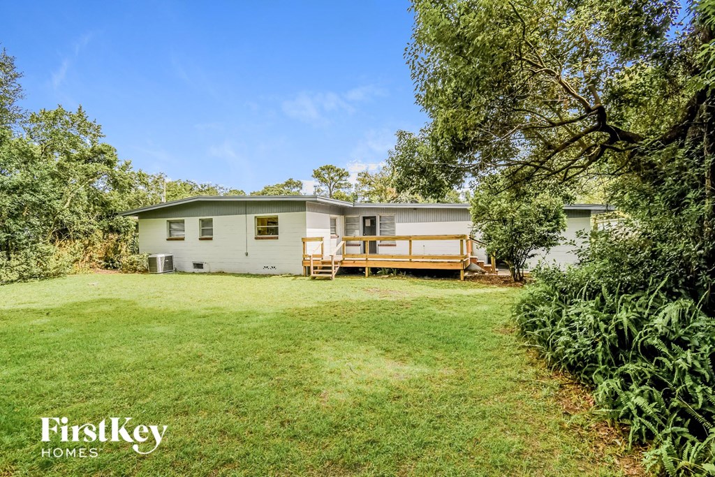a white house with a yard and a deck
