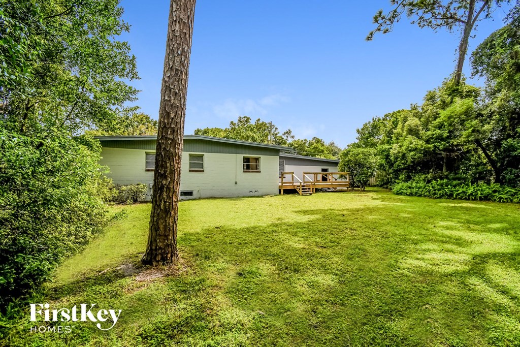 a white house with a yard and a tree