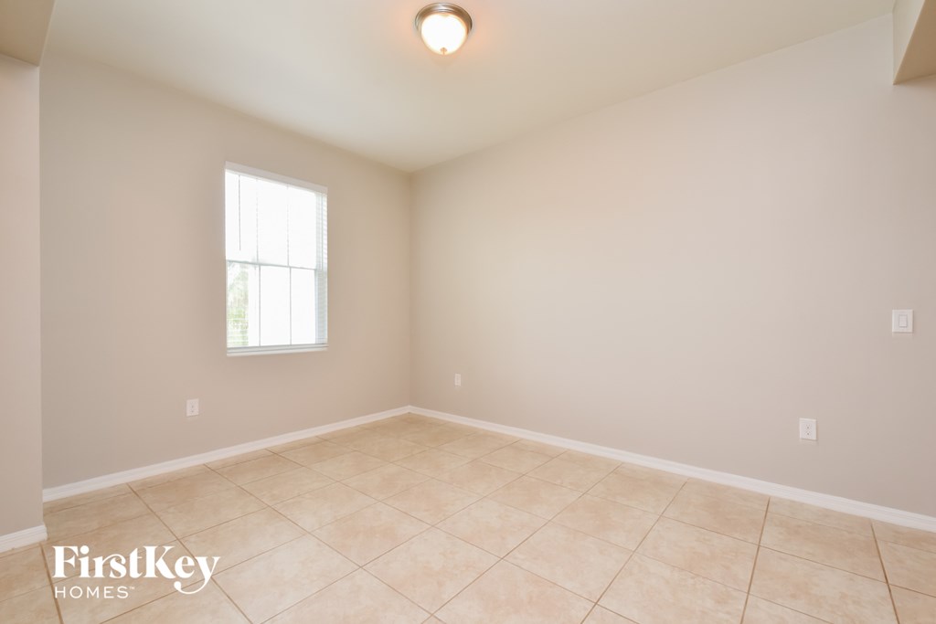 A room with a window and tiled floor.