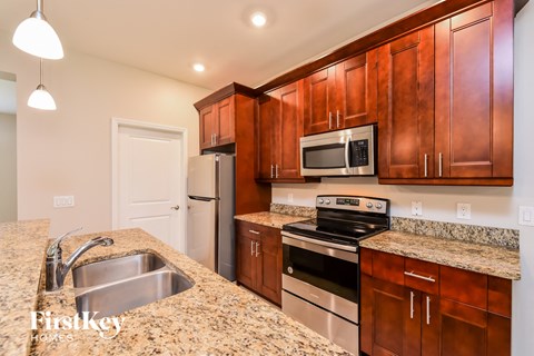 A kitchen with brown cabinets and a granite countertop.